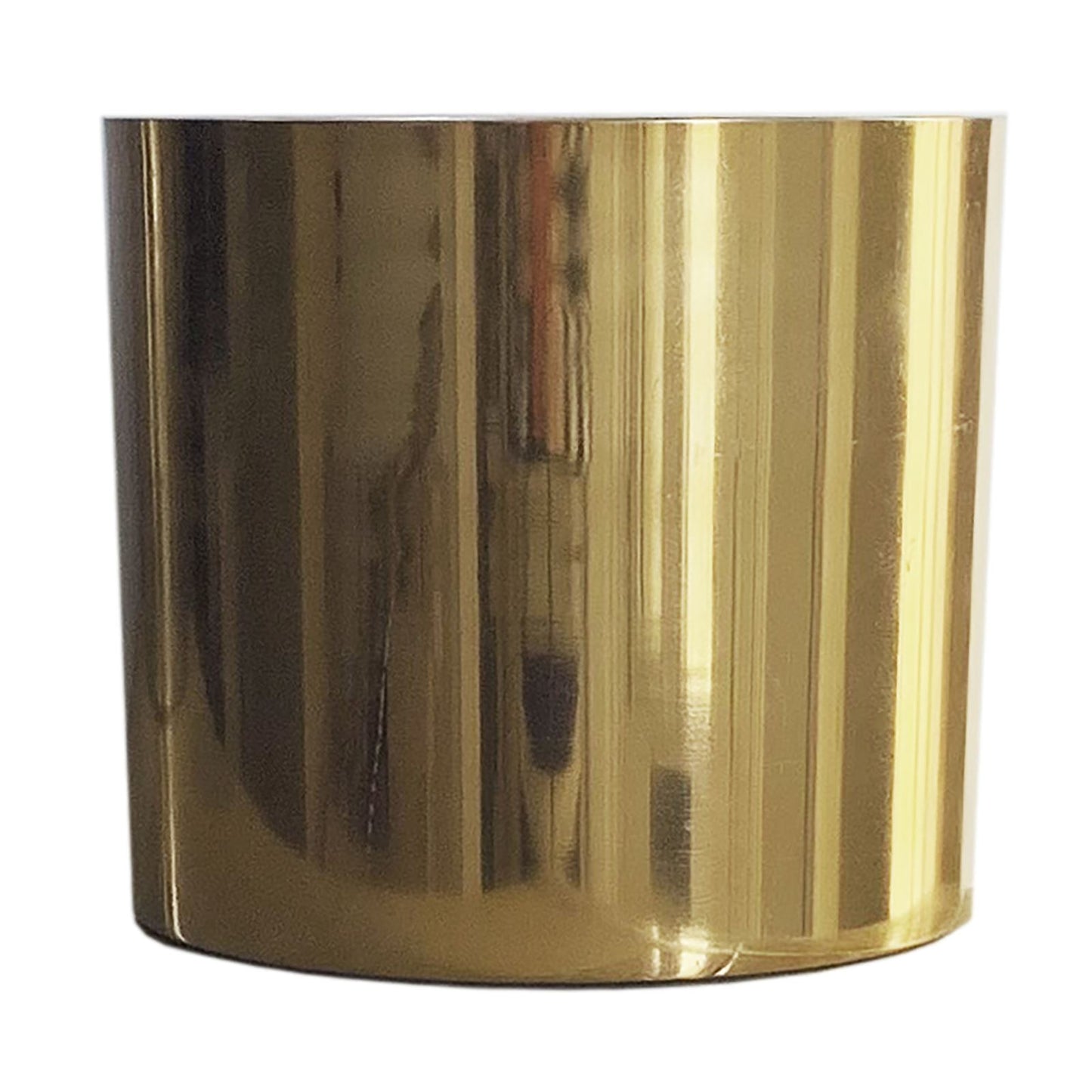 Polished gold metal planter, cylindrical shape, empty, set against a plain white background.
