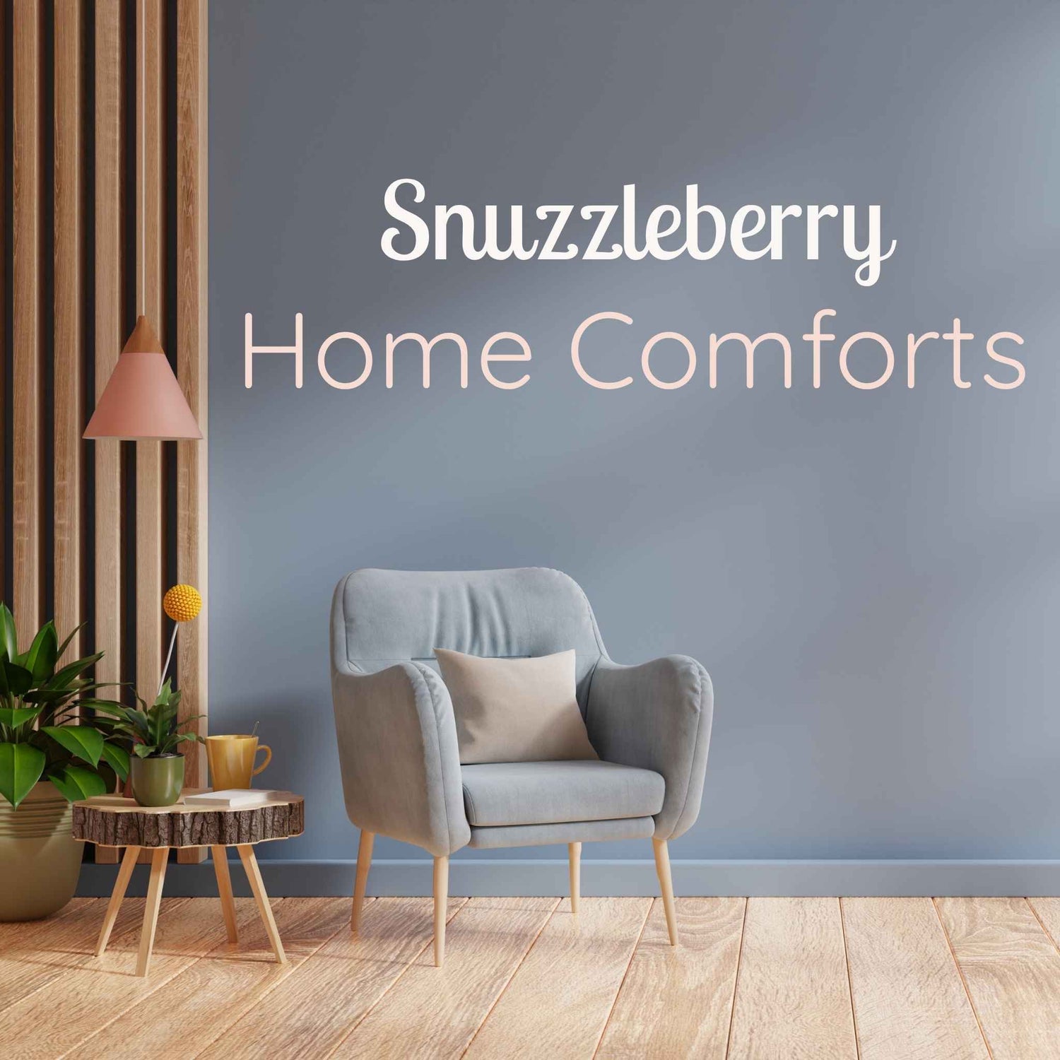 Cosy living room corner with soft blue armchair, wooden side table, and potted plants, styled under the Snuzzleberry Home Comforts collection banner.