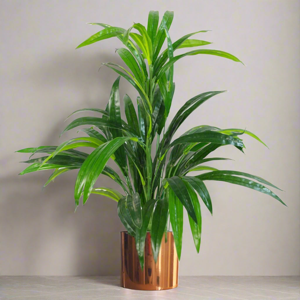 Artificial bamboo shrub in a glossy copper metal planter.