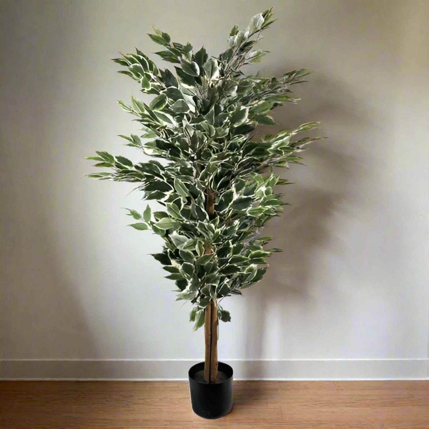 130cm artificial variegated ficus tree in a black pot positioned against a light wall and wood floor.