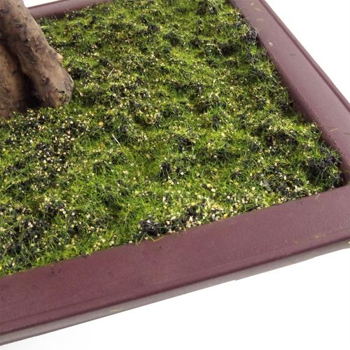 Detailed view of an artificial green moss base within a square black planter.