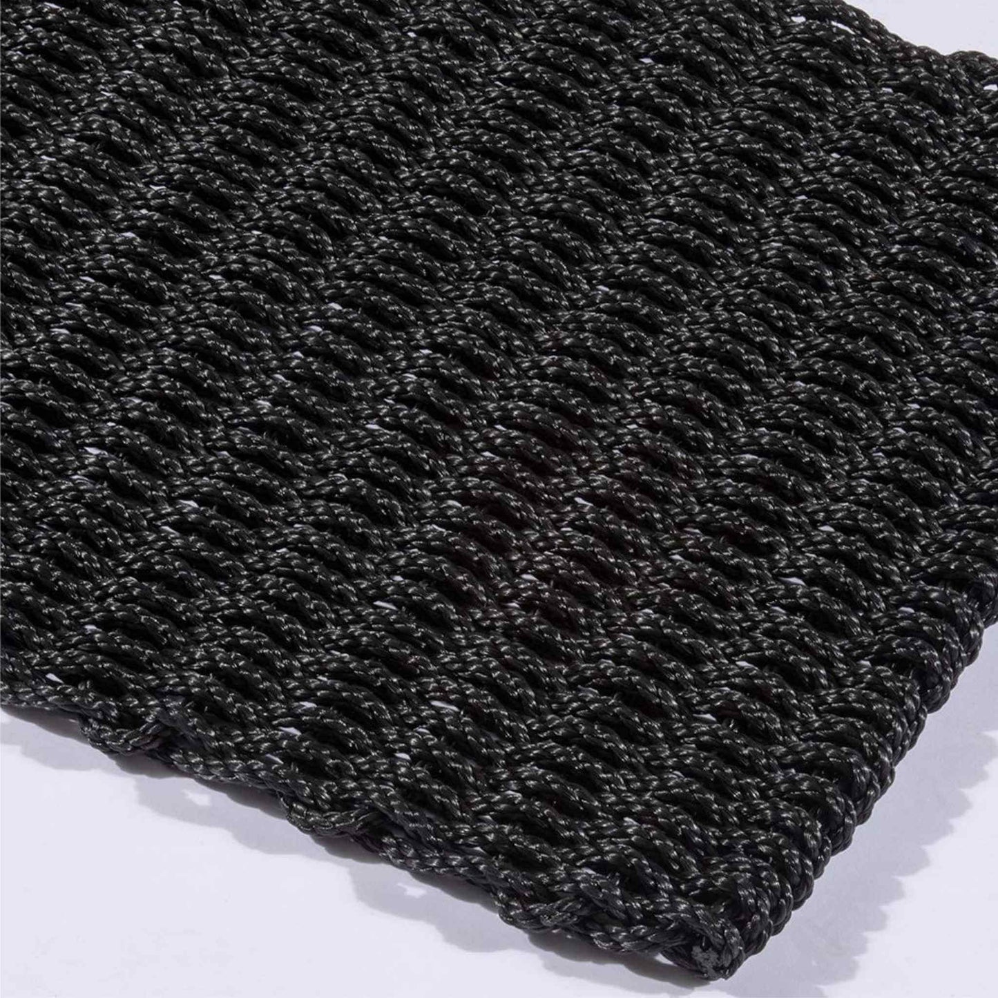 Corner detail of Didsbury navy polypropylene doormat with thick braided pattern.
