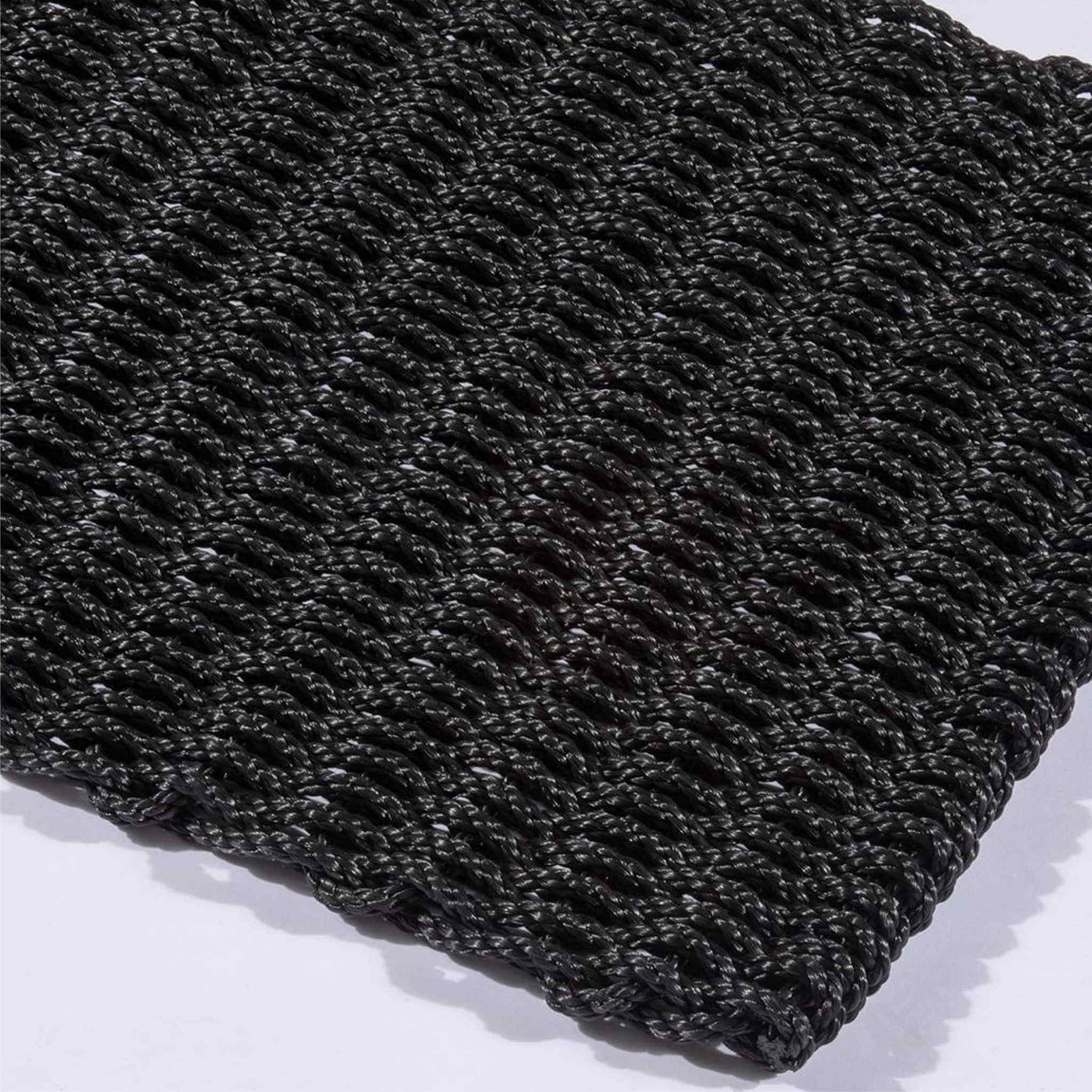 Corner detail of Didsbury navy polypropylene doormat with thick braided pattern.