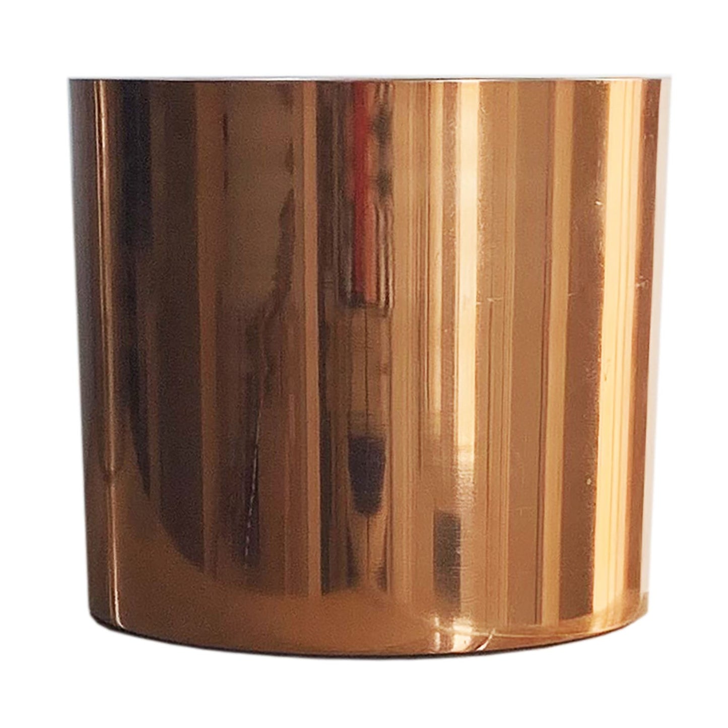 Close-up of a shiny copper-finish metal planter, cylindrical.