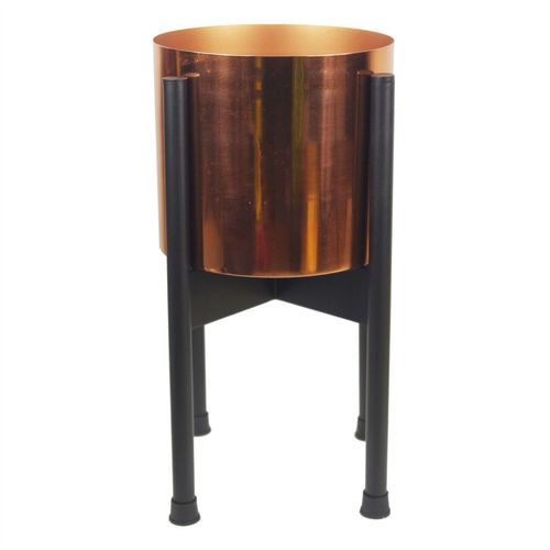 A polished copper planter placed in a sleek black stand, perfect for raised display.