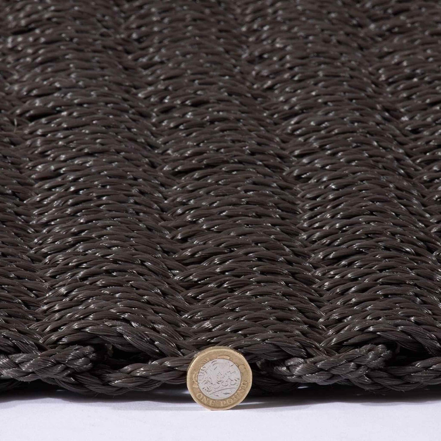 Side view of the Didsbury doormat with a pound coin for thickness reference.