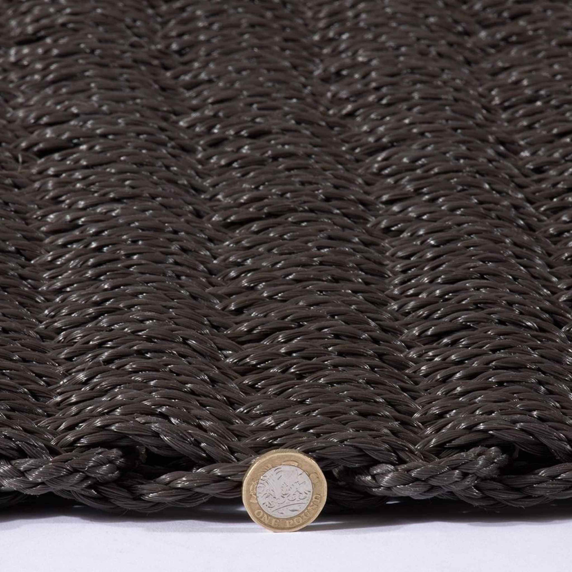 Side view of the Didsbury doormat with a pound coin for thickness reference.