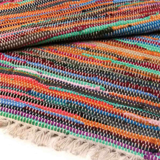 Folded handmade cotton rag rug in assorted bright stripes with soft cotton tasselled fringe.