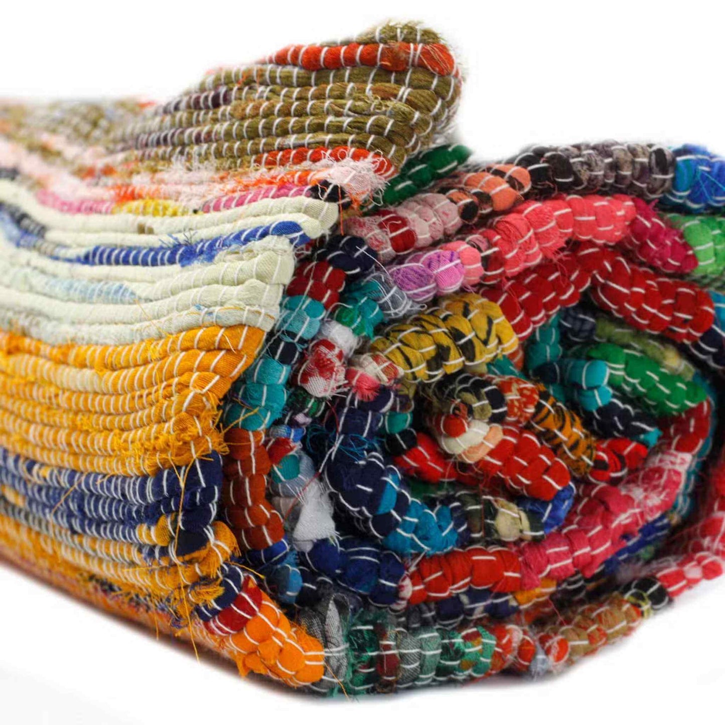 Close-up of a rolled multicoloured Indian rag rug showing handwoven cotton fabric with visible stitched texture and vibrant stripes.