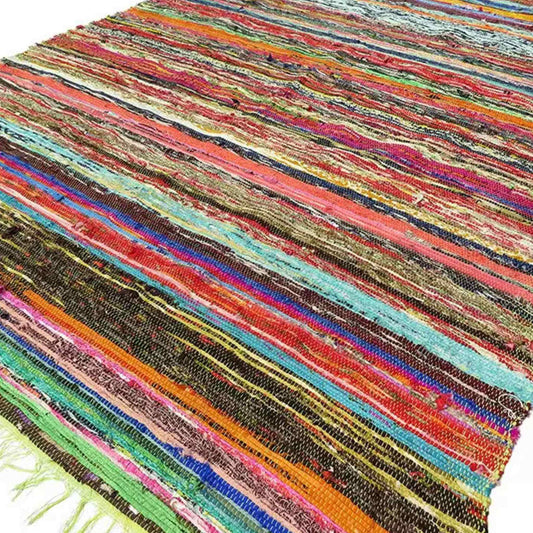 Flatlay of a multicoloured striped cotton rag rug showing woven texture.