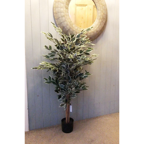 Artificial ficus tree with variegated foliage displayed indoors under a round wall mirror.