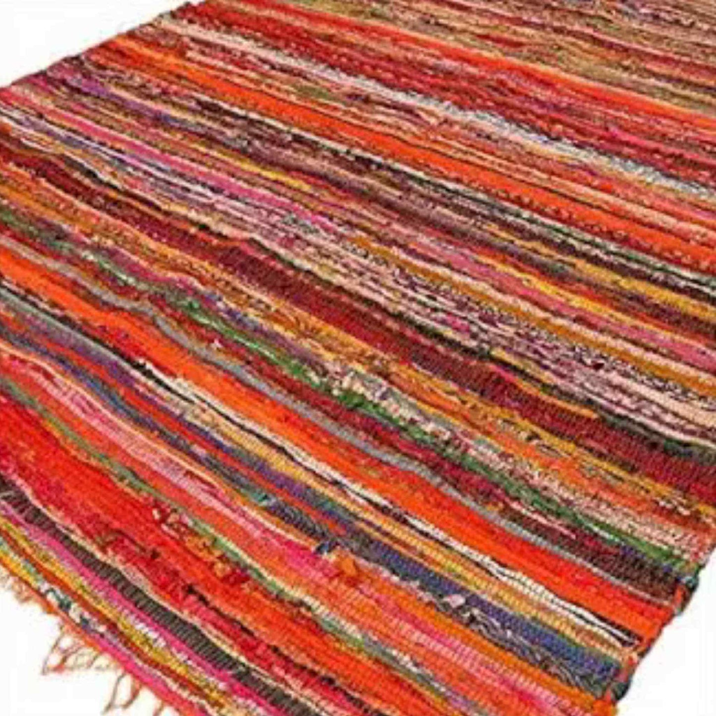 Handwoven orange luxury rag rug showing vibrant recycled fabric stripes in red, pink, green, and gold.