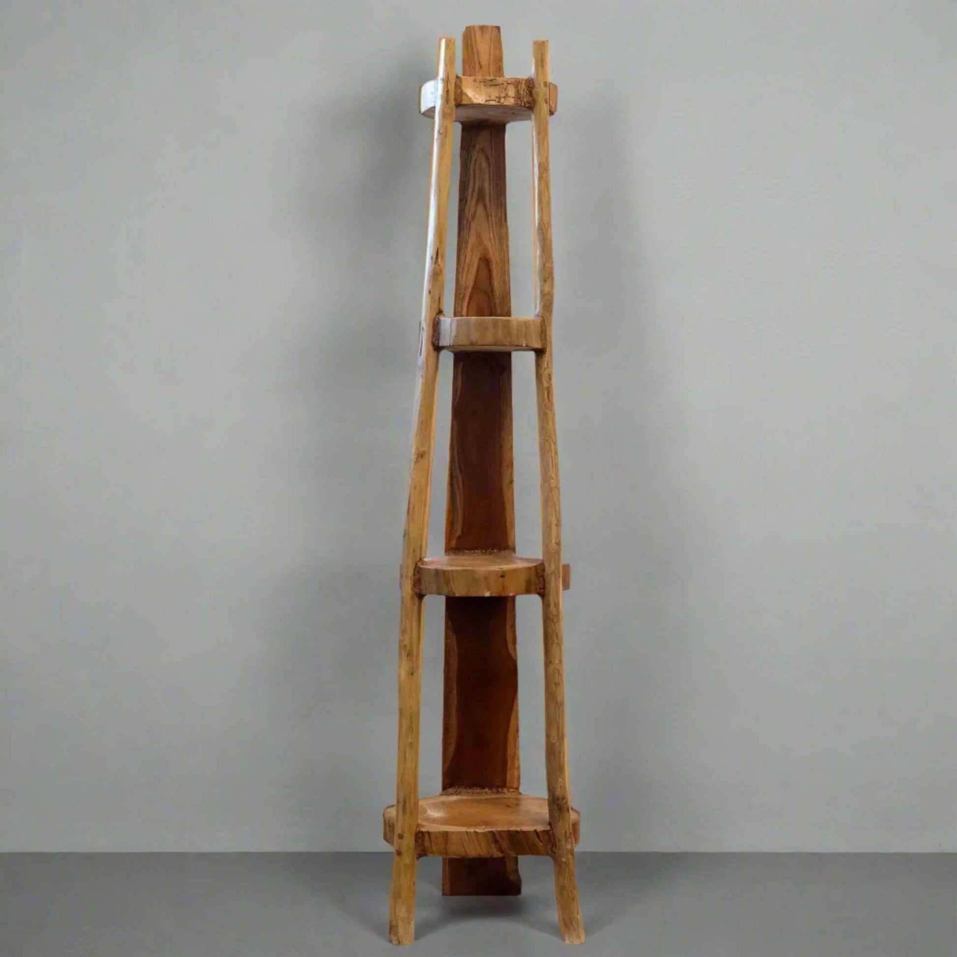 Natural teak 135cm corner unit with four fixed shelves, showing smooth wood grain and tapered shape against a grey wall.