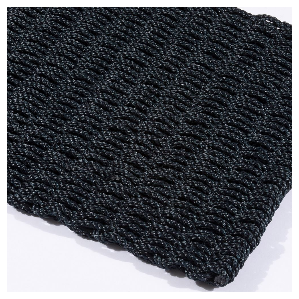 Angled view of rectangular navy braided doormat on white background.