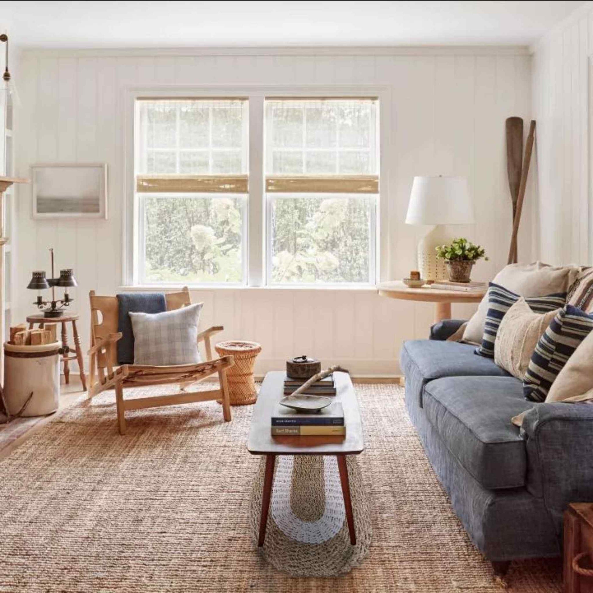 White and tan oval seagrass rug styled under a coffee table in a bright living room.
