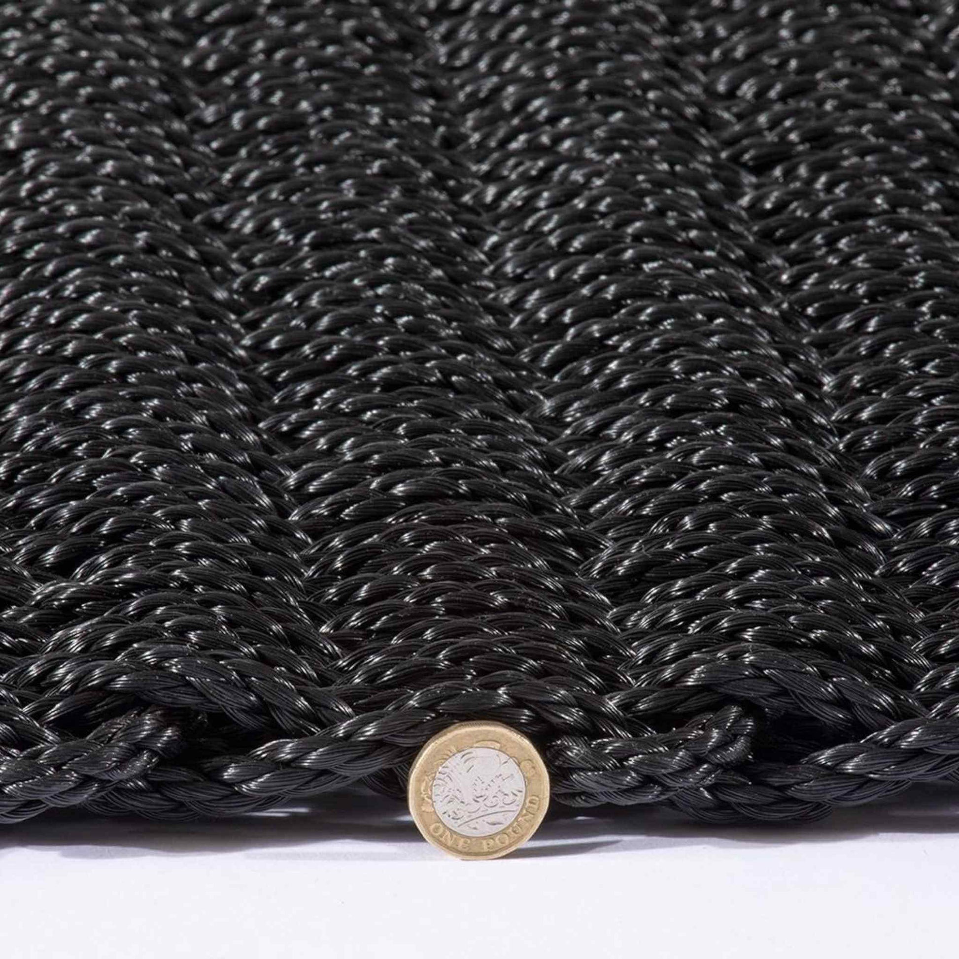 Charcoal Didsbury braided doormat with one-pound coin to show thickness.