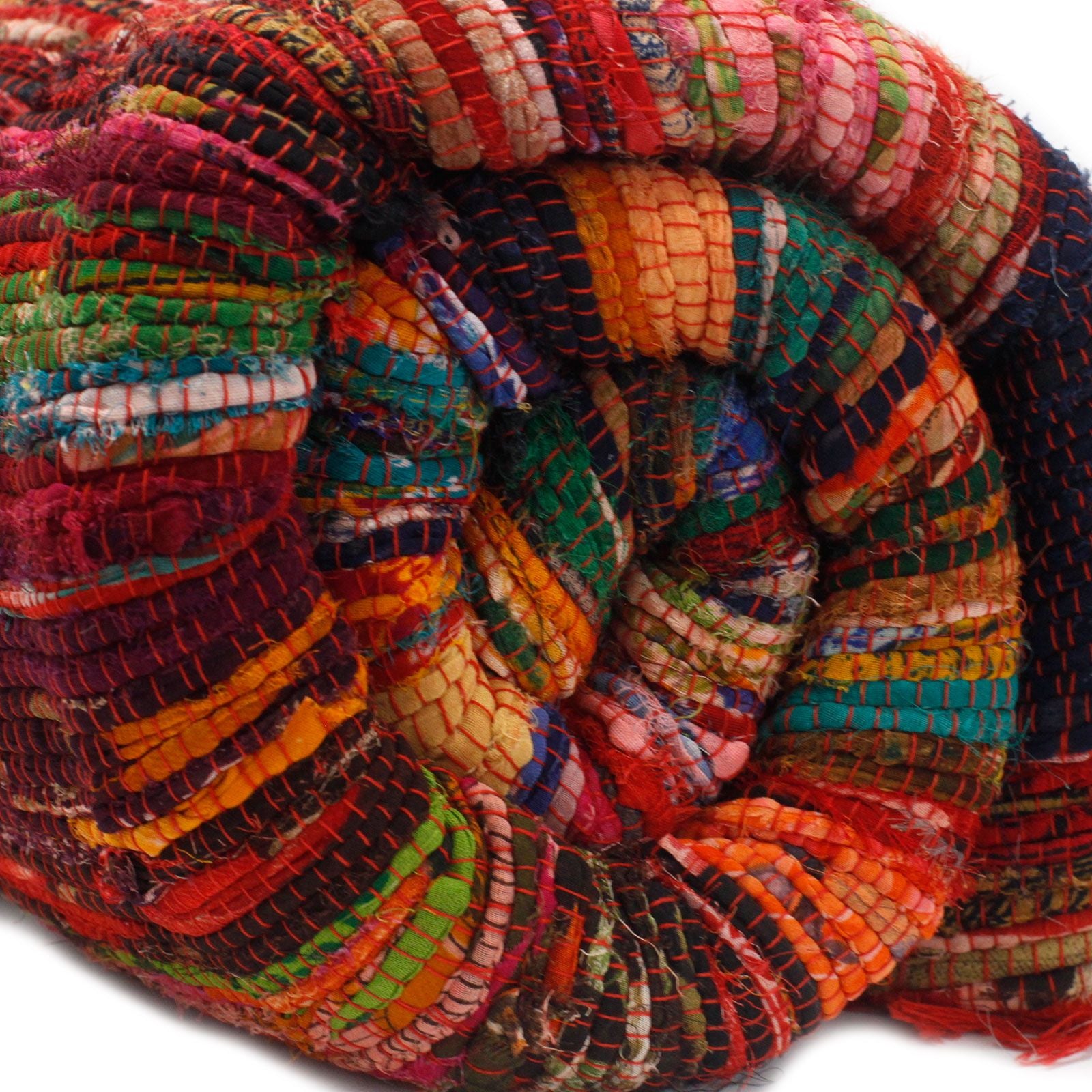 Rolled red-based rag rug with a visible multicoloured weave, showcasing its soft texture.