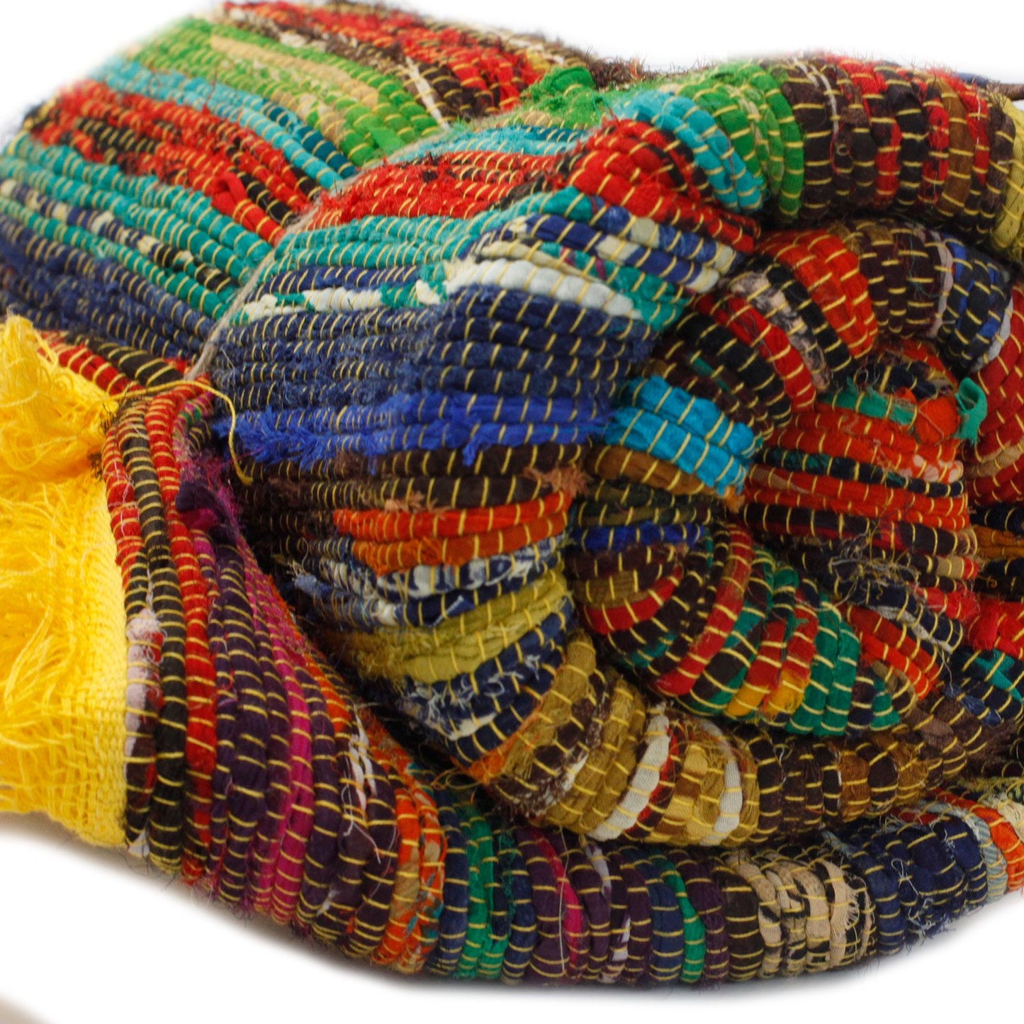 Rolled multi-coloured rag rug with a visible yellow edge and tight weave.