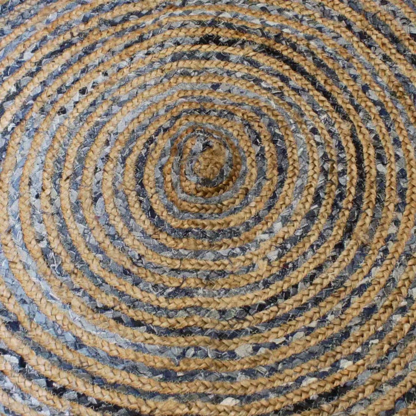 Close-up of round braided rug made from jute and recycled denim, showing detailed circular weave and natural texture.