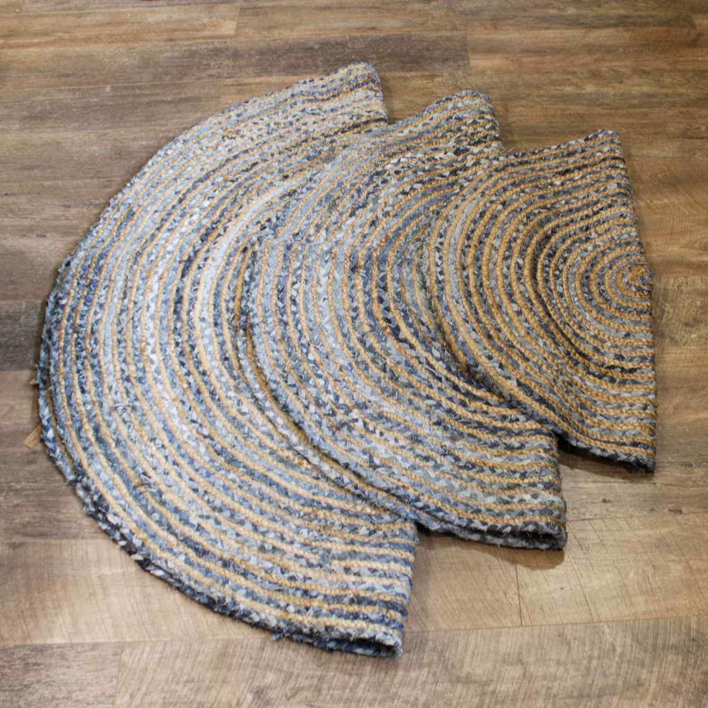 Set of three round jute and recycled denim rugs in 90cm, 120cm, and 150cm sizes, shown stacked on a wooden floor with natural beige and denim blue braiding.
