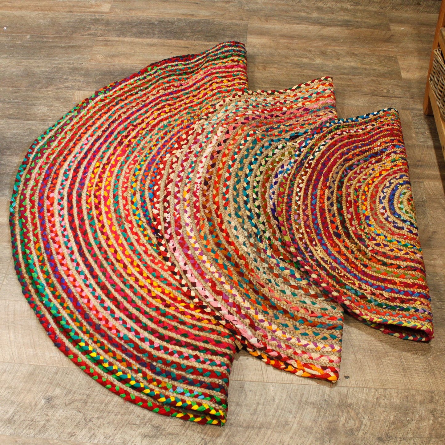 Three round jute and recycled cotton rugs in different sizes laid out on wooden flooring, showing scale and pattern variety.