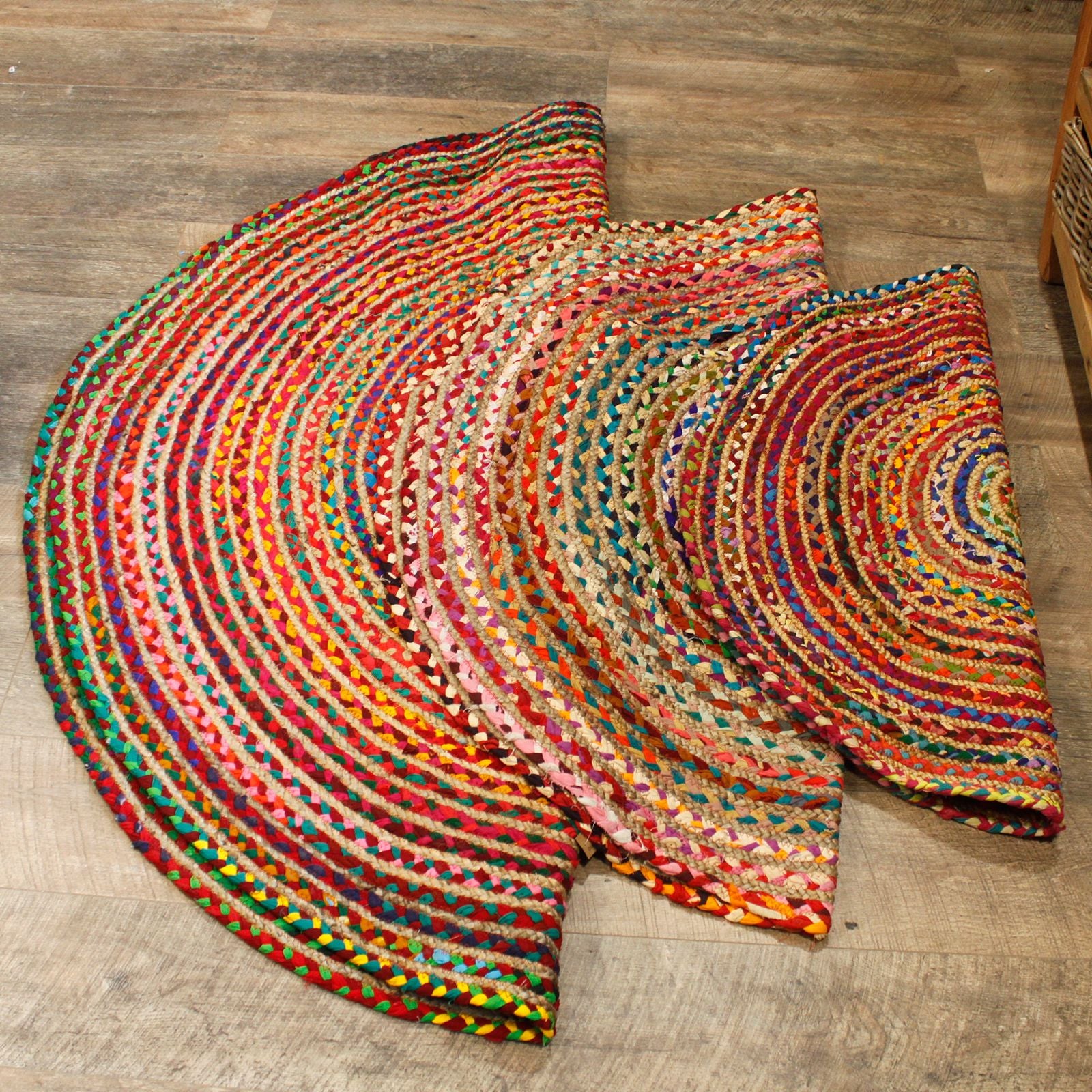 Three round jute and recycled cotton rugs in different sizes laid out on wooden flooring, showing scale and pattern variety.