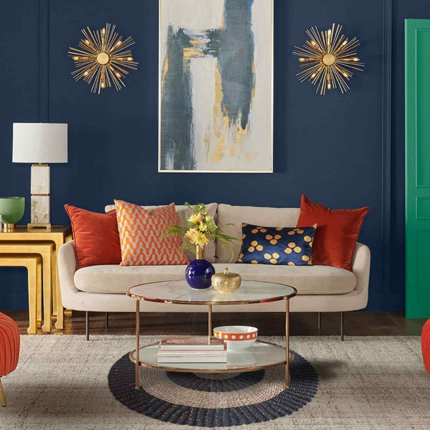 Black and tan seagrass rug placed beneath a glass coffee table in a modern living room with navy walls and orange accents.