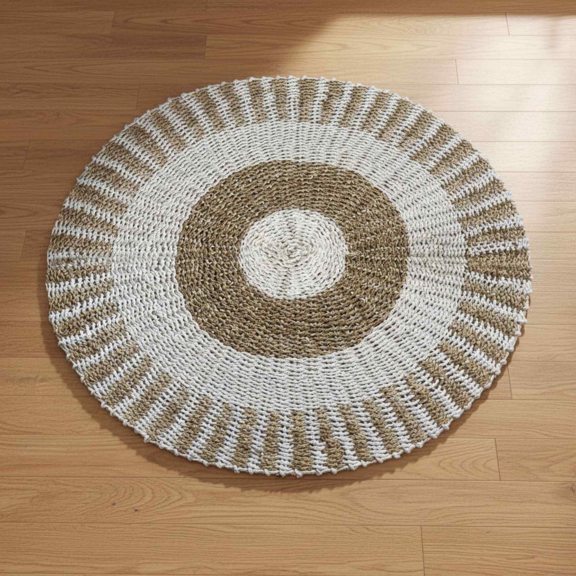 One metre round seagrass rug with sun pattern on wooden floor showing full design.