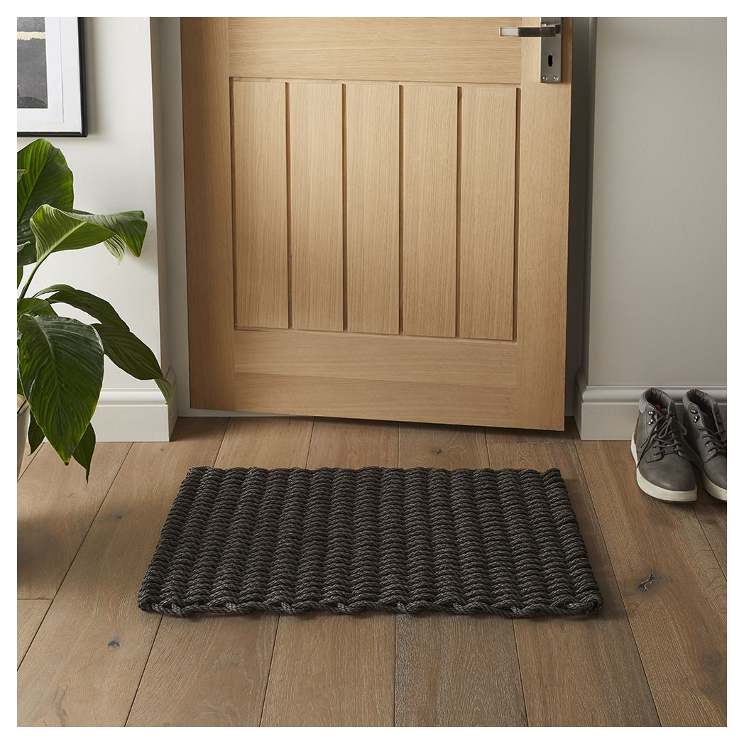 Dark slate braided polypropylene doormat 45x75cm placed by a wooden front door.