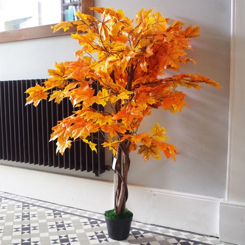 Full view of a tall, 125cm artificial orange maple tree in a black weighted pot standing against a white wall.