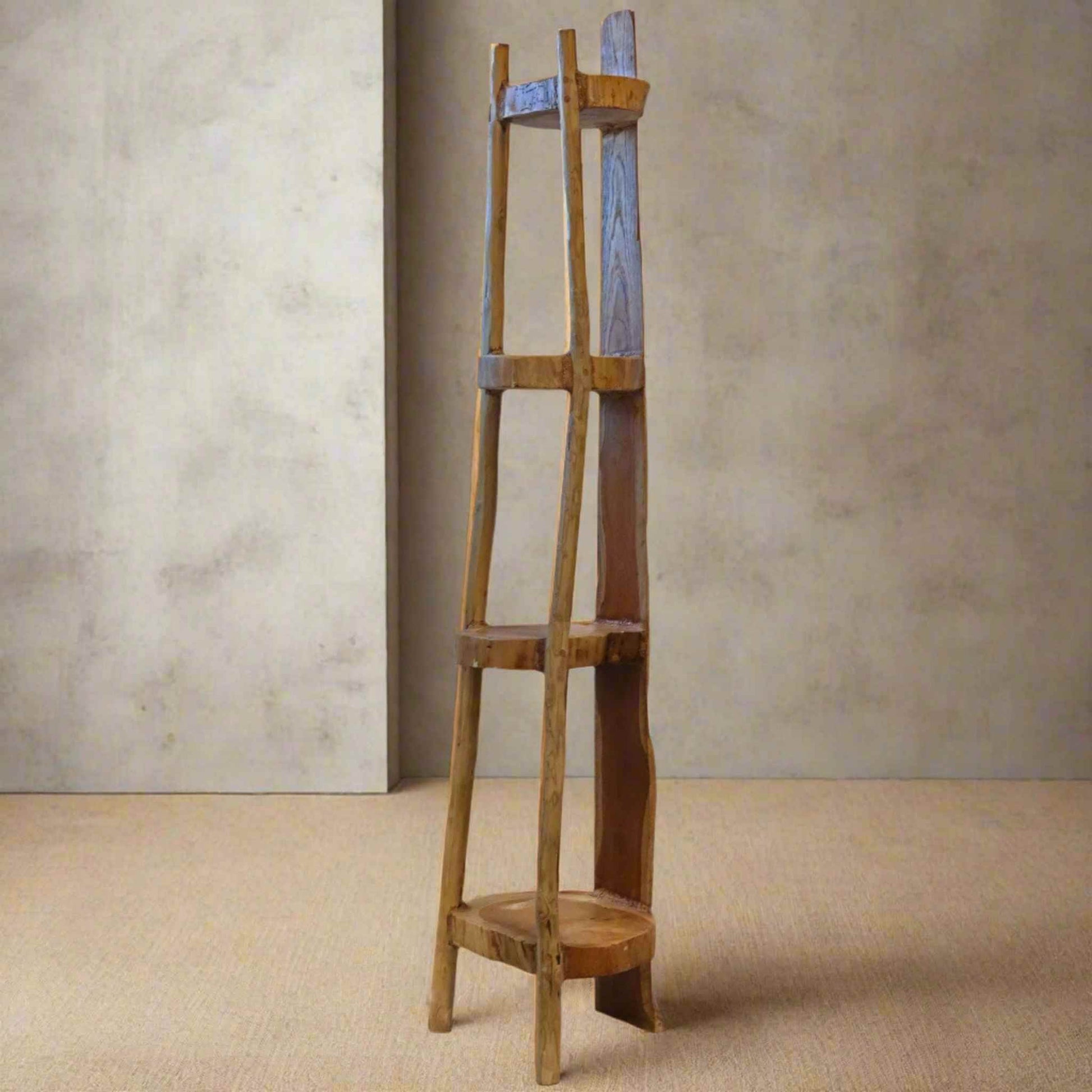 Natural teak 135cm corner shelf with four fixed shelves, styled in a softly lit neutral room with warm flooring and beige walls, showing elegant tapered shape and smooth wood grain.