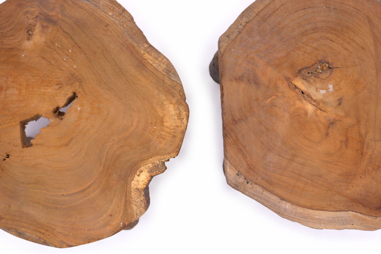 Overhead close-up of two teak slab tops highlighting natural knots, rings and irregular edges.