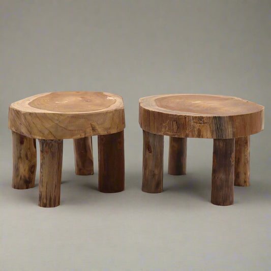 Pair of medium teak wood display stands with round, organic slab tops and four chunky legs.