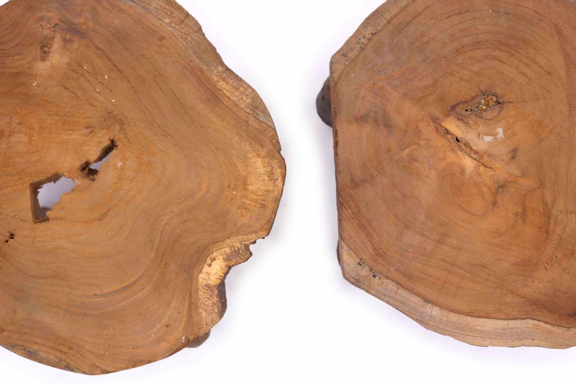 Close‑up of teak wood surfaces on two display stands showing distinctive grain and natural texture.