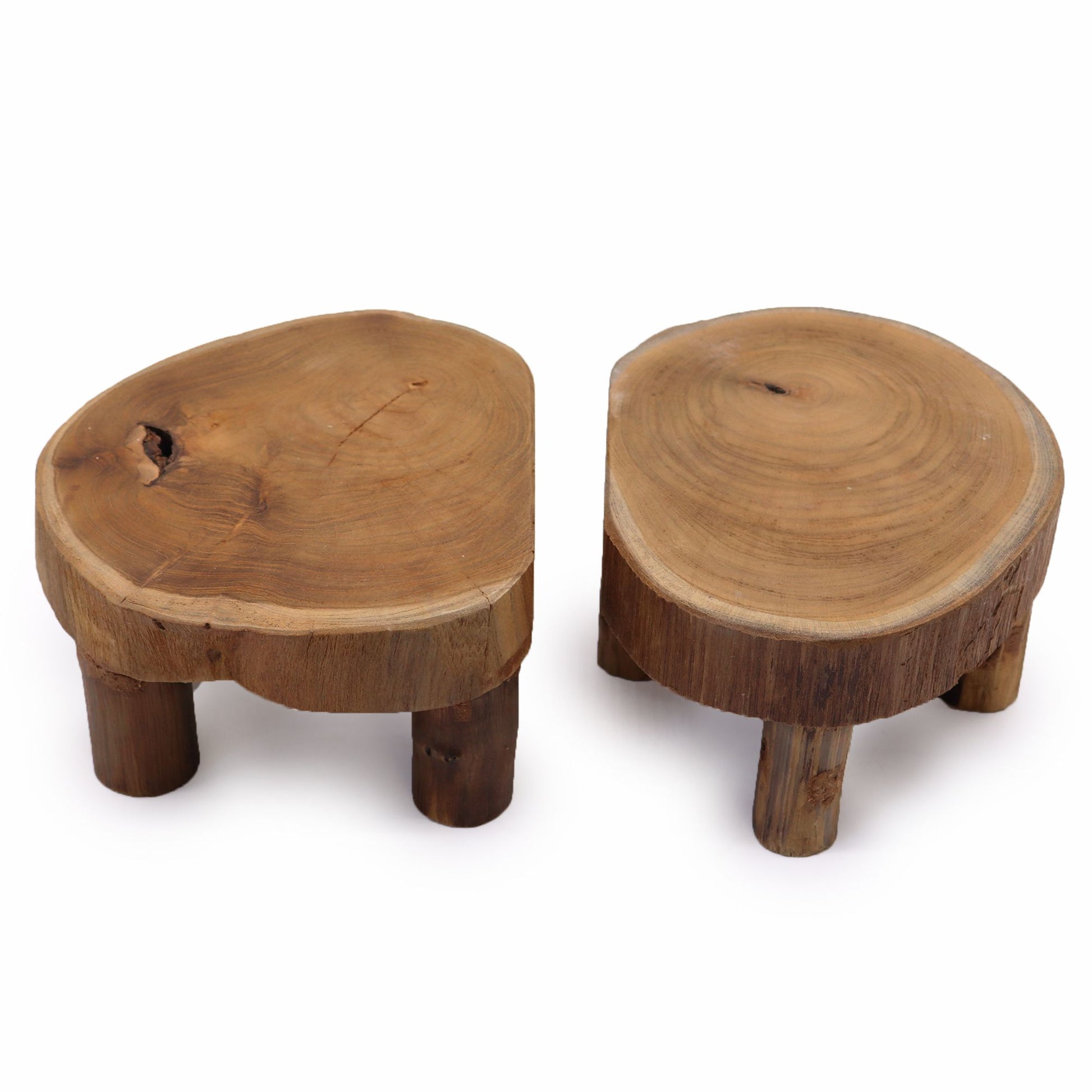 Set of two small round teak wood display stands with natural grain, low three-leg design, on a white background.